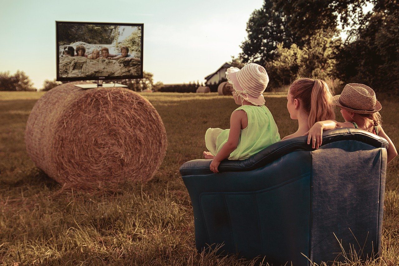 Familie schaut TV auf einem Feld